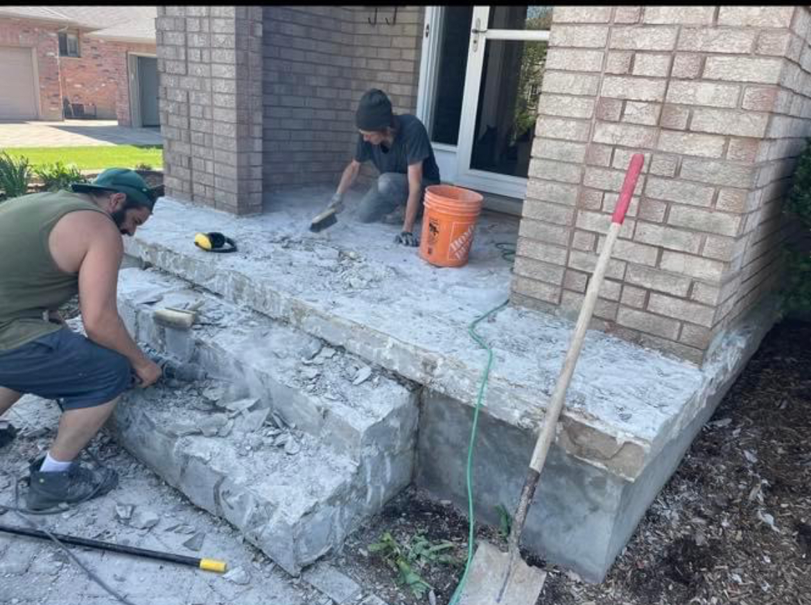 Workers removing damaged concrete from a residential porch and steps before restoration in London Ontario