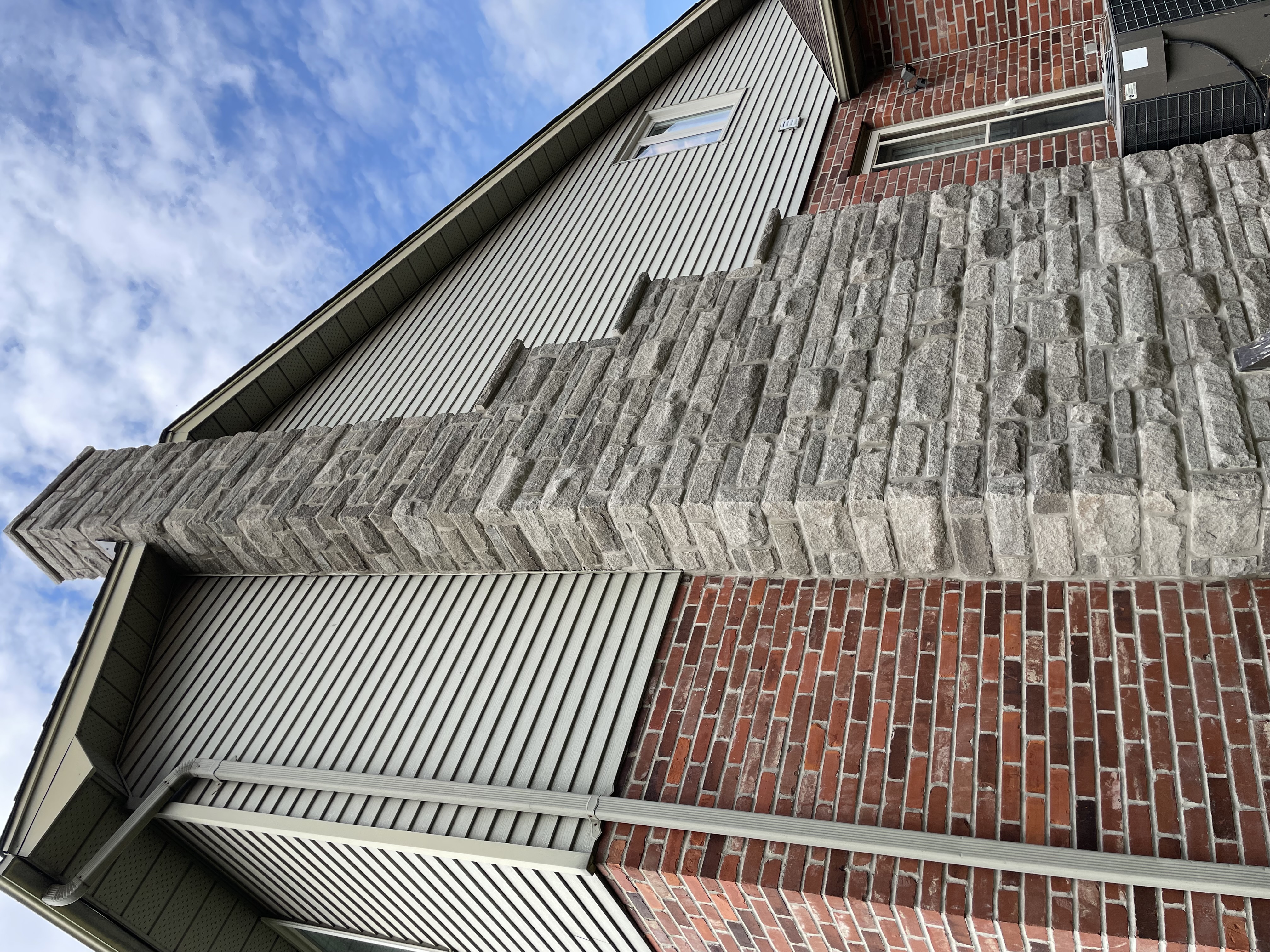 Same house with newly installed stone veneer chimney showing enhanced curb appeal and craftsmanship in London Ontario