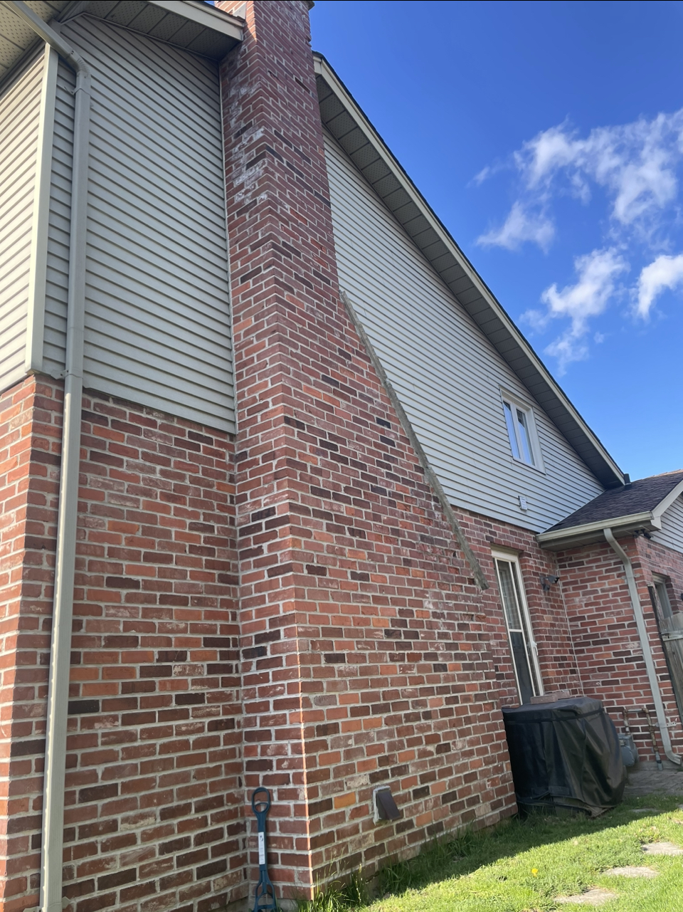Side view of a house showing original red brick chimney before stone refacing in London Ontario